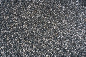 A detailed view of numerous small black chia seeds forming a textured background.