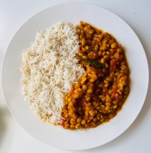 Close-up of a plate with aromatic lentil curry paired with fluffy white rice, perfect for dining.