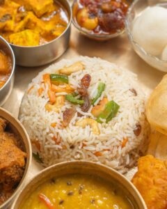 Colorful Indian thali with rice, curry, and sides, offering a taste of traditional cuisine.